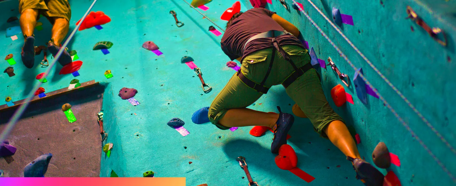 A climber working up an indoor climbing wall